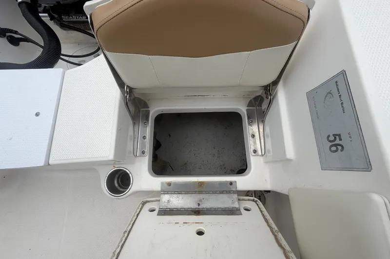 Slide: The Image of 2015 Robalo R200 Center Console boat seat storage compartment with cup holder and seat number 56. - 51