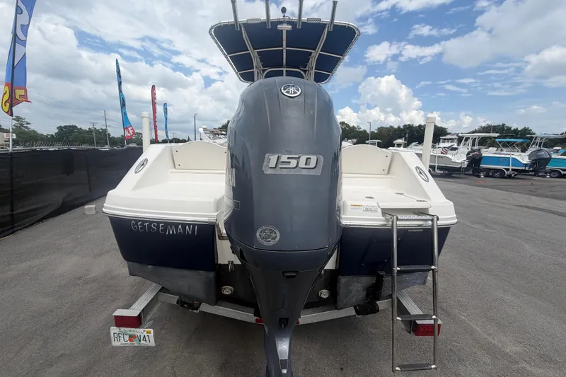Slide: The Image of 2015 Robalo R200 Center Console boat covered on trailer, parked beside RVs. - 59