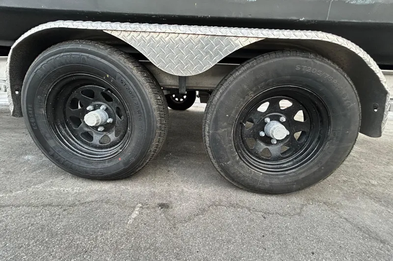 Slide: The Image of Trailer wheels for 2015 Robalo R200 Center Console boat on pavement. - 60