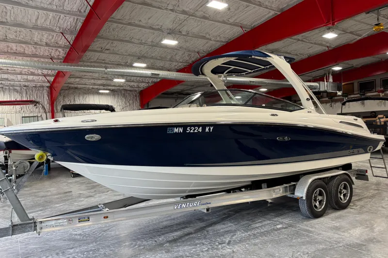 The Image of 2011 Sea Ray SLX 250 boat on trailer in indoor storage facility. - 1