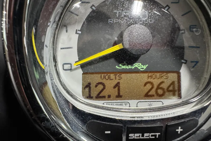 Slide: The Image of Close-up of 2011 Sea Ray SLX 250 gauge showing 12.1 volts and 264 hours. - 12