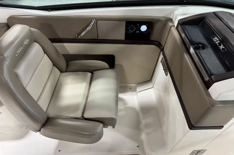 Slide: The Image of 2011 Sea Ray SLX 250 interior with beige seating and control panel. - 8
