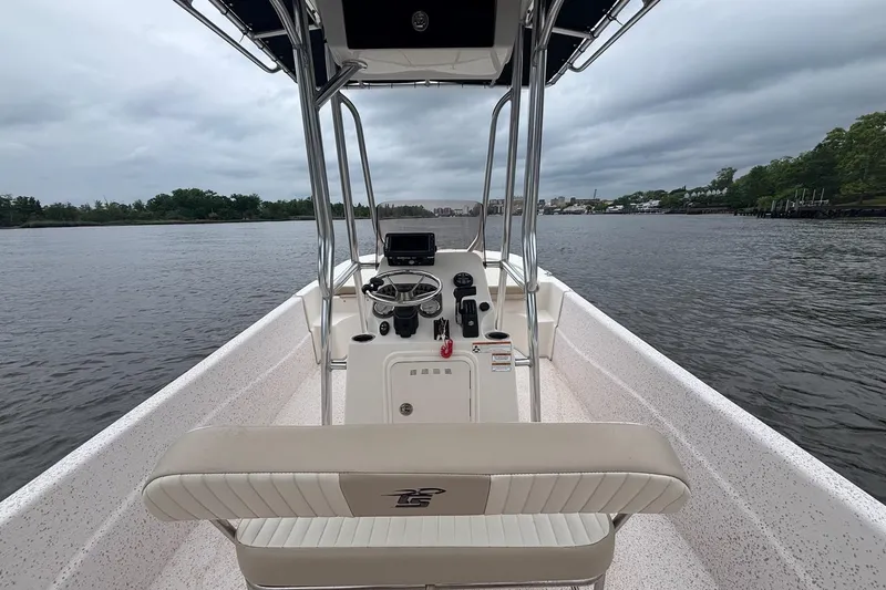 Slide: The Image of 2019 Carolina Skiff 218 DLV boat on calm water, featuring a central console and seating. - 12