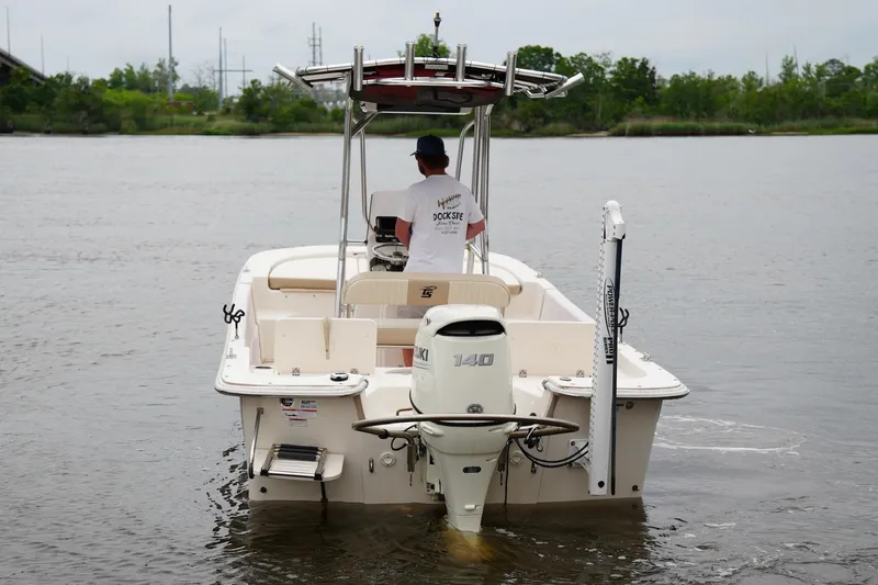 Slide: The Image of 2019 Carolina Skiff 218 DLV boat on water, rear view with outboard motor. - 4