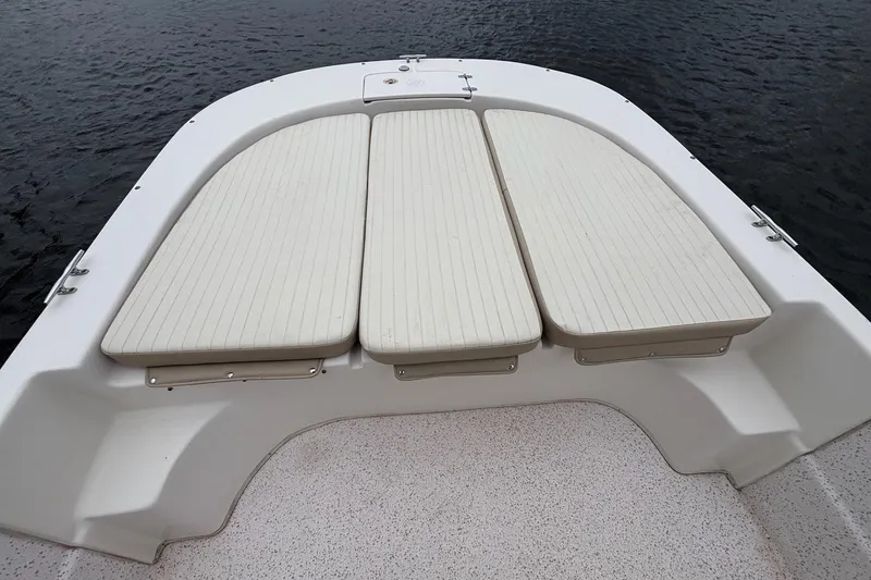 Slide: The Image of 2019 Carolina Skiff 218 DLV boat deck with cushioned seating on calm water. - 7