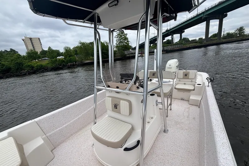 Slide: The Image of 2019 Carolina Skiff 218 DLV boat on a river, under a cloudy sky. - 9