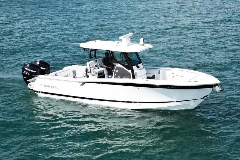 The Image of 2023 Blackfin 302 CC boat cruising on clear blue water. - 0