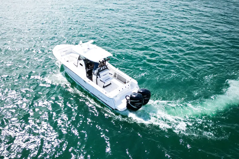 Slide: The Image of 2023 Blackfin 302 CC boat cruising on open water, showcasing sleek design and powerful engines. - 10