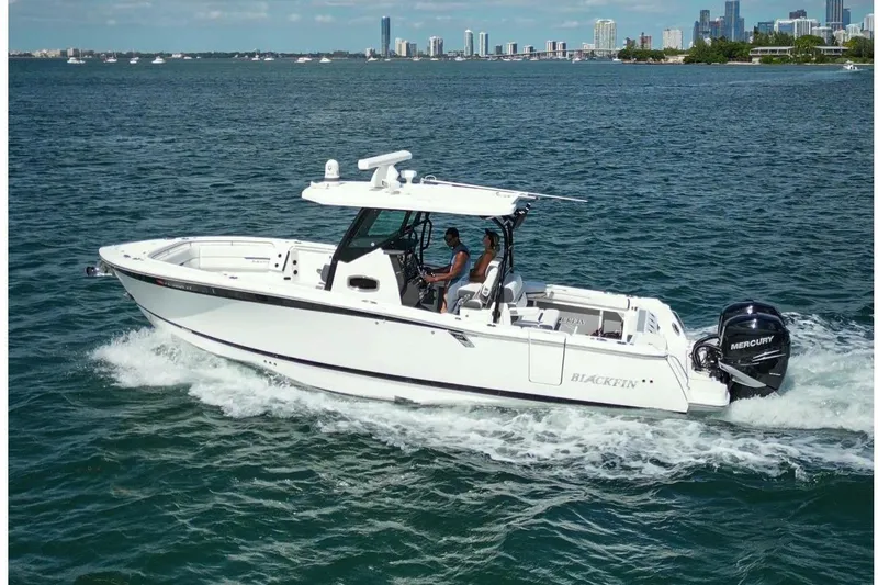 Slide: The Image of 2023 Blackfin 302 CC boat cruising on open water under a clear blue sky. - 11