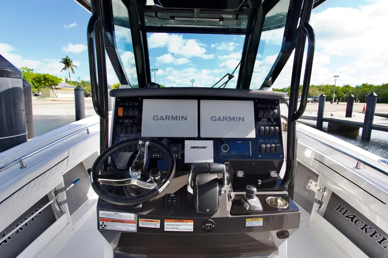 Slide: The Image of 2023 Blackfin 302 CC boat dashboard with Garmin displays and Mercury controls. - 12
