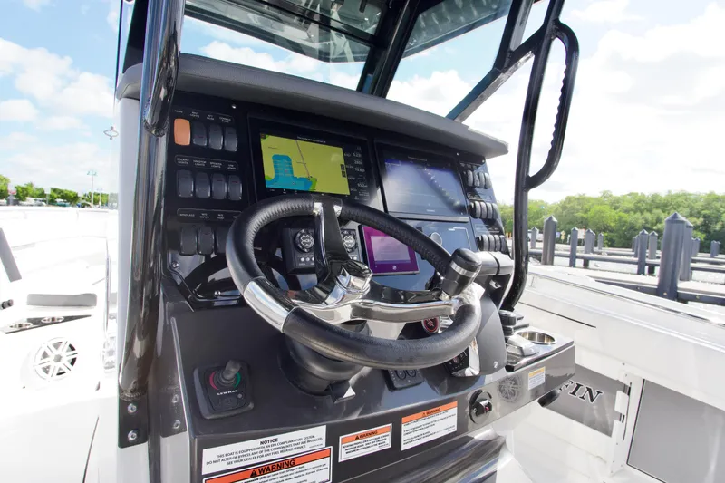 Slide: The Image of 2023 Blackfin 302 CC boat dashboard with advanced navigation controls and steering wheel. - 15
