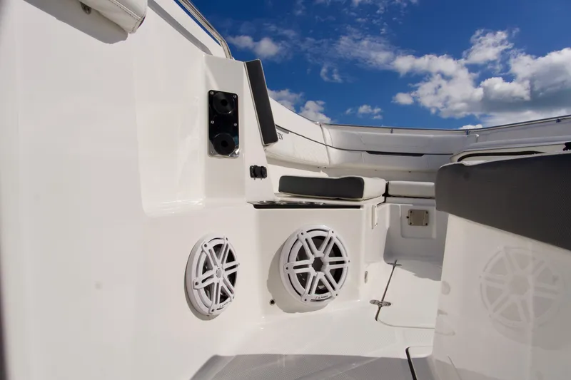 Slide: The Image of 2023 Blackfin 302 CC boat interior with speakers and seating under a blue sky. - 17