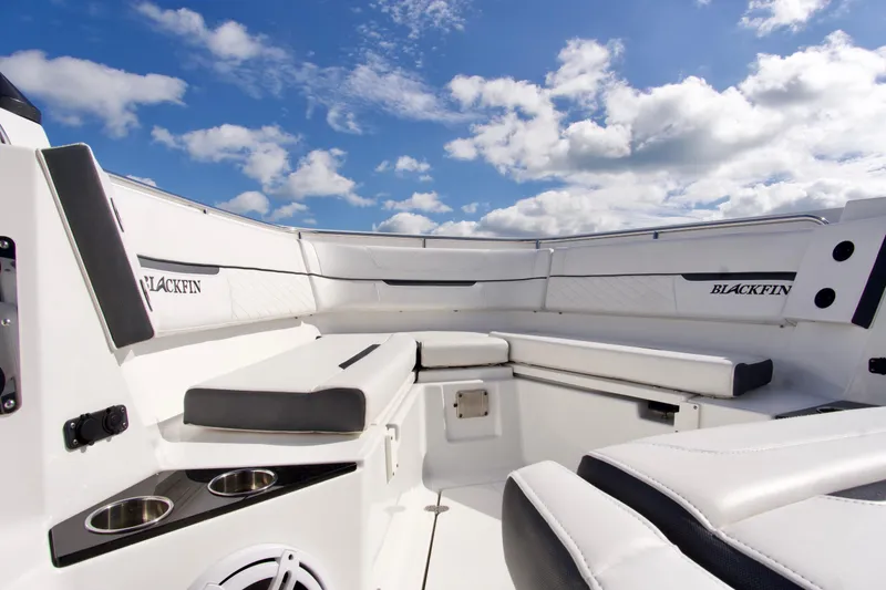 Slide: The Image of 2023 Blackfin 302 CC boat interior with white seating under a blue sky. - 18