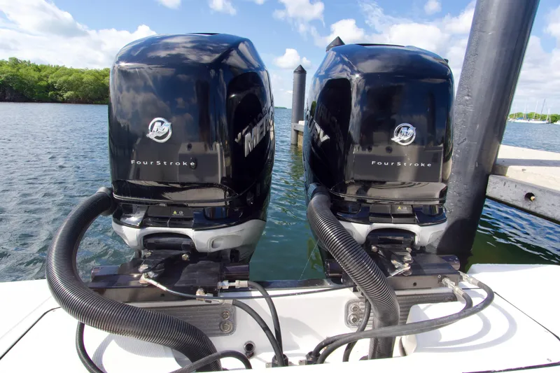 Slide: The Image of Twin Mercury FourStroke engines on a 2023 Blackfin 302 CC boat, docked by the water. - 24