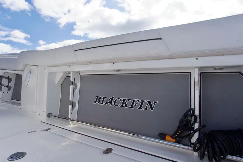 Slide: The Image of 2023 Blackfin 302 CC boat interior with storage compartment and logo. - 25