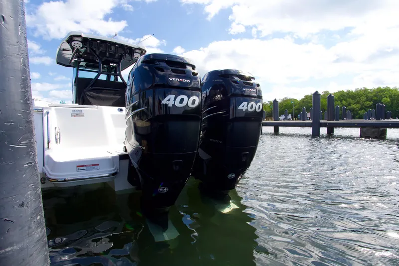 Slide: The Image of 2023 Blackfin 302 CC boat with twin Mercury Verado 400 engines docked in sunny marina. - 27