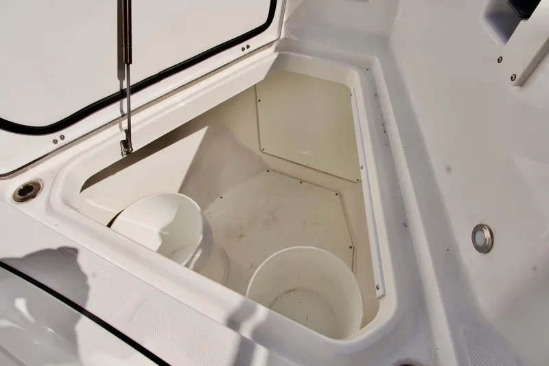 Slide: The Image of Storage compartment on 2023 Blackfin 302 CC boat, featuring white interior and bucket. - 34