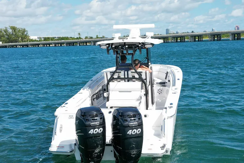 Slide: The Image of 2023 Blackfin 302 CC boat cruising on blue water with dual 400 horsepower engines. - 7