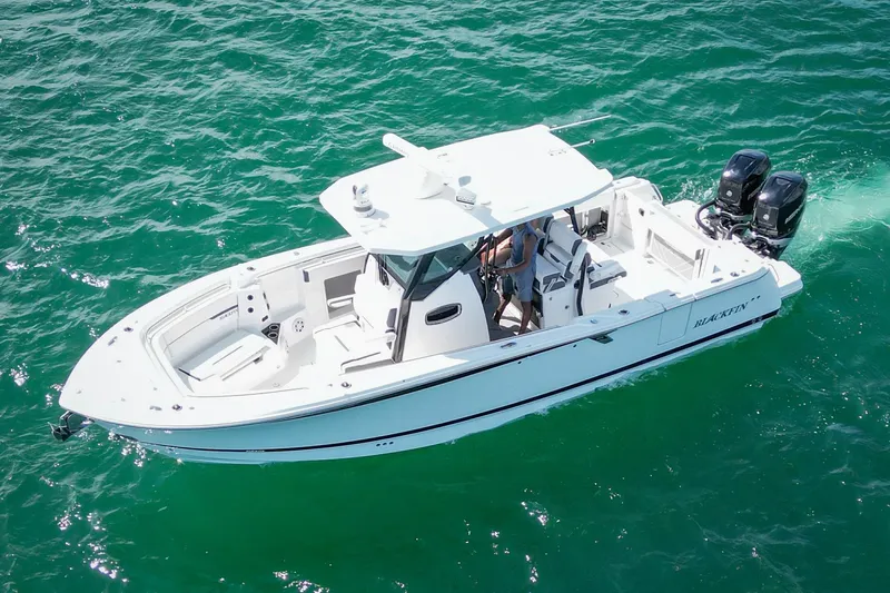 Slide: The Image of 2023 Blackfin 302 CC boat cruising on clear blue water. - 8