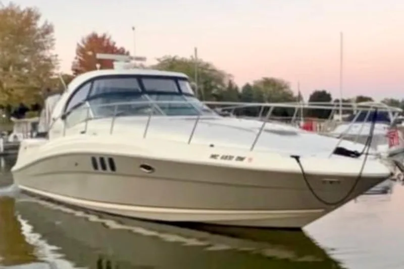 Slide: The Image of 2006 Sea Ray Sundancer 400 yacht docked at sunset with autumn trees in background. - 1