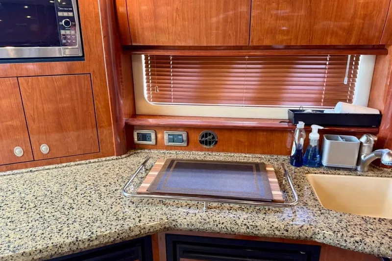 Slide: The Image of Luxurious 2006 Sea Ray Sundancer 400 yacht kitchen with granite countertops and wooden cabinetry. - 17