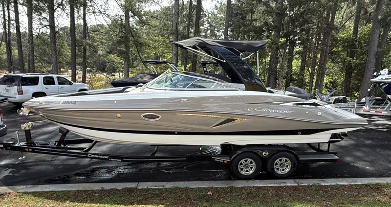 The Image of 2020 Crownline 290 SS boat on trailer parked in forest. - 1