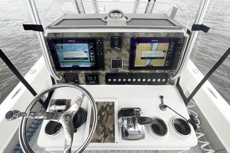 Slide: The Image of Control panel of a 2013 Prowler 25 boat with navigation screens and steering wheel. - 13