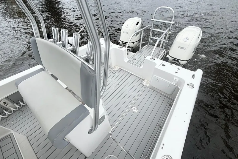 Slide: The Image of 2013 Prowler 25 boat with dual engines, sleek seating, and spacious deck on water. - 16