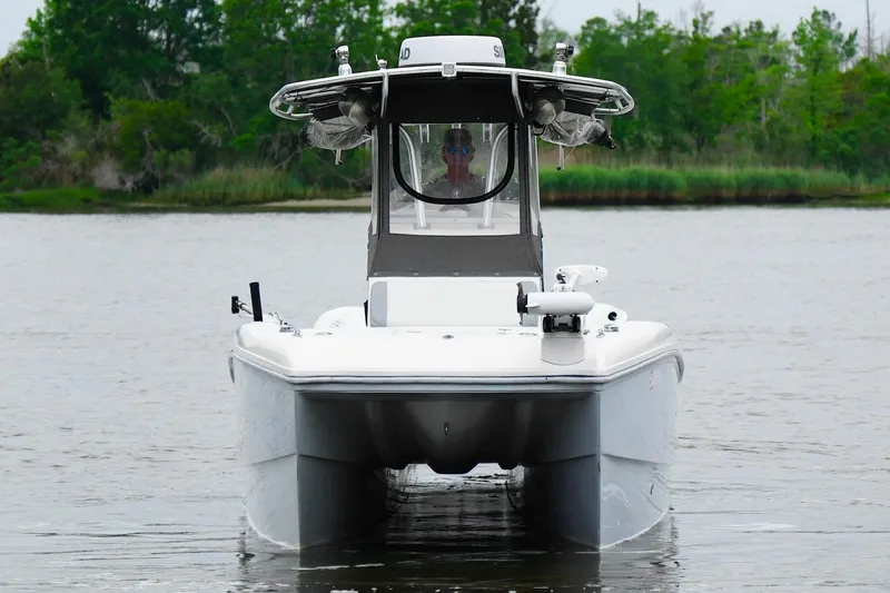 Slide: The Image of 2013 Prowler 25 boat on calm water, surrounded by lush greenery. - 4
