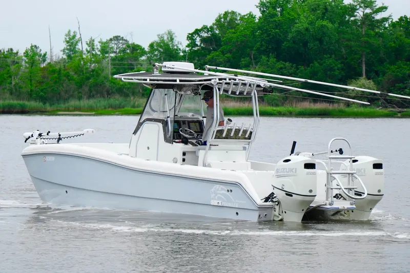Slide: The Image of 2013 Prowler 25 boat with dual Suzuki engines cruising on a calm river. - 6