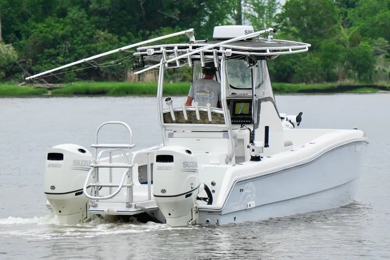 Slide: The Image of 2013 Prowler 25 boat with dual Suzuki engines cruising on a calm river. - 7