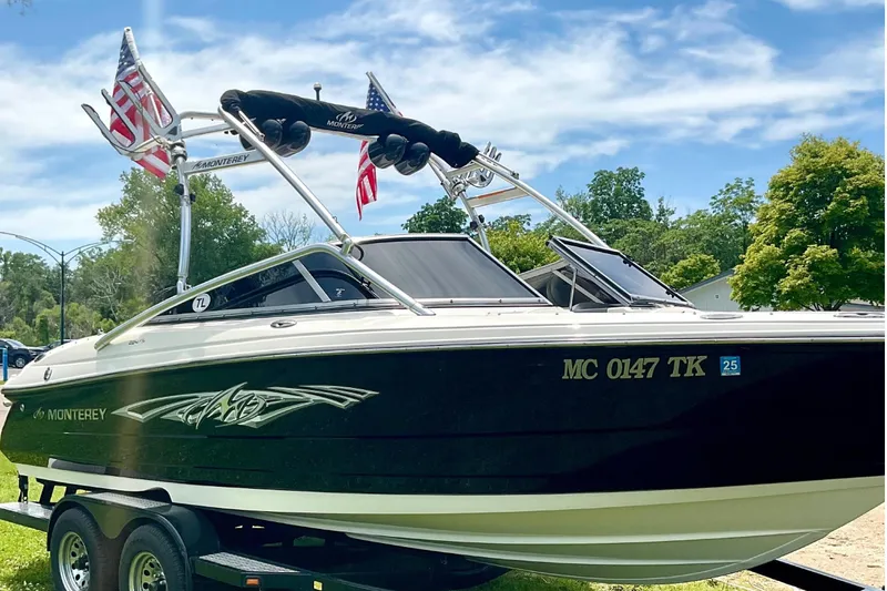 Slide: The Image of 2012 Monterey 224FS boat with trailer and flags outdoors. - 5