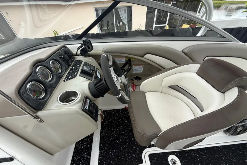 Slide: The Image of Interior of a 2012 Yamaha Boats 242 Limited S, featuring steering wheel and dashboard controls. - 13
