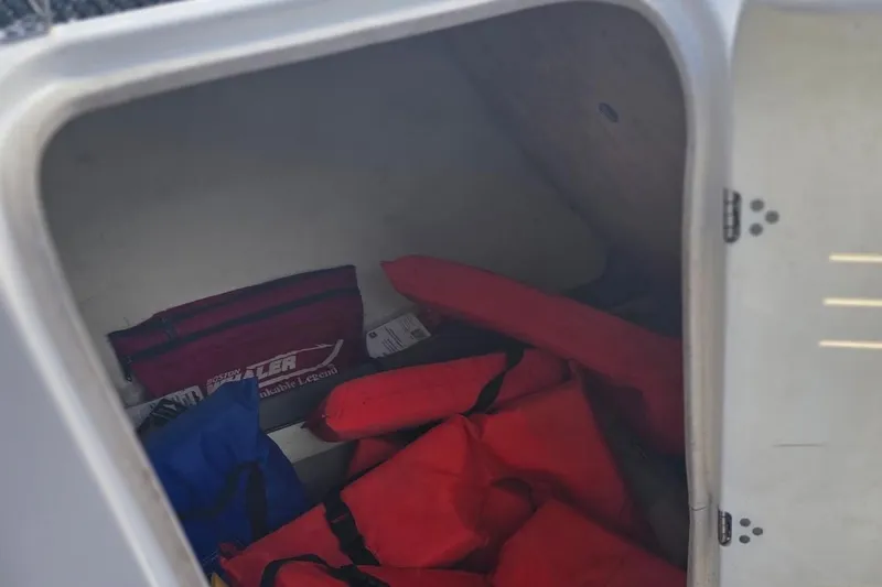 Slide: The Image of Storage compartment of 2012 Yamaha Boats 242 Limited S with life jackets and gear. - 14
