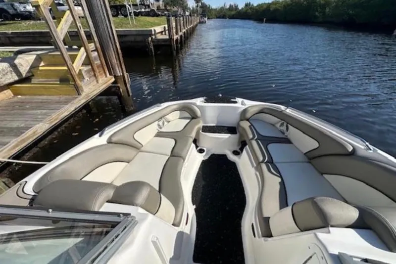 Slide: The Image of 2012 Yamaha Boats 242 Limited S interior with spacious seating on a calm waterway. - 17