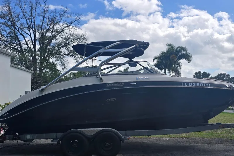 Slide: The Image of 2012 Yamaha Boats 242 Limited S on trailer, parked outdoors under a cloudy sky. - 3