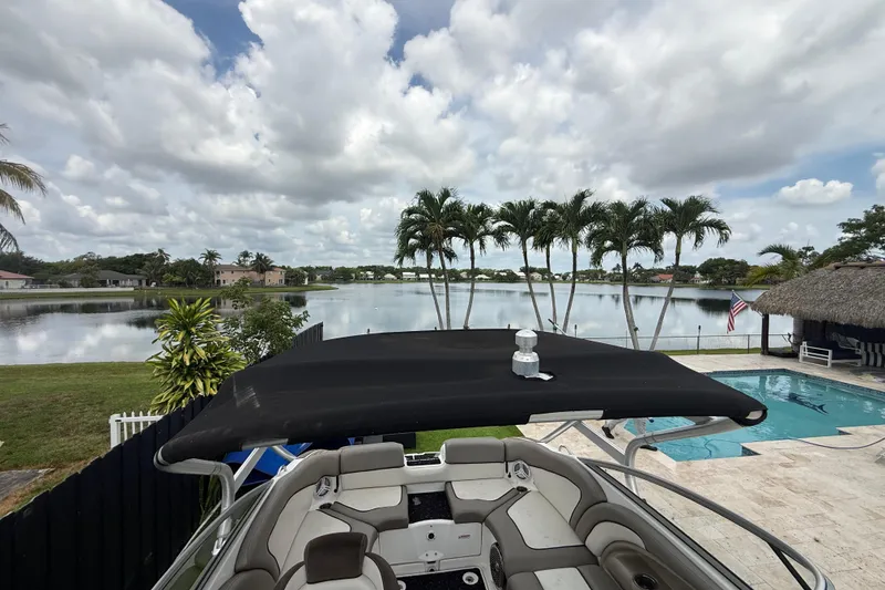 Slide: The Image of 2012 Yamaha Boats 242 Limited S overlooking a serene lake and poolside view. - 23