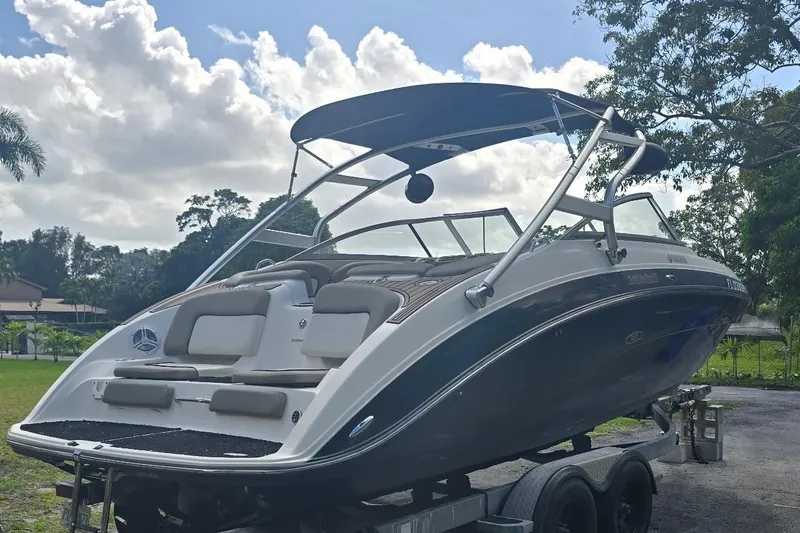 Slide: The Image of 2012 Yamaha Boats 242 Limited S on trailer, sleek design, outdoor setting. - 4