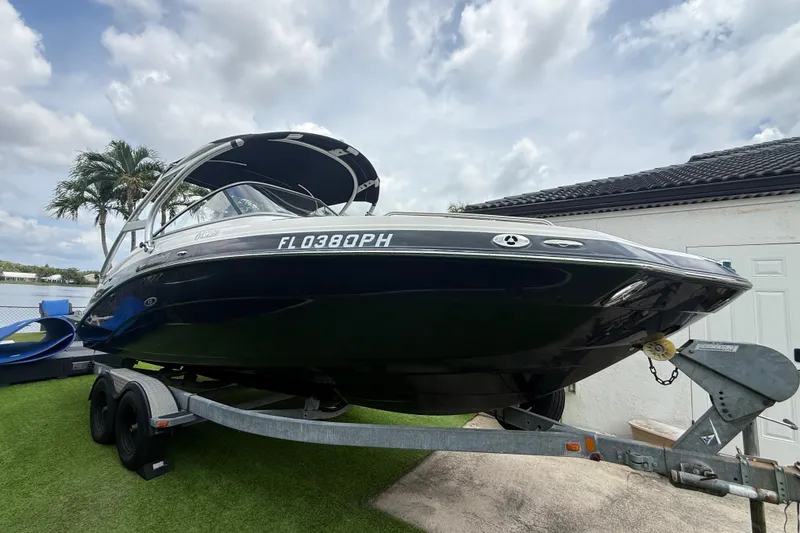 The Image of 2012 Yamaha Boats 242 Limited S on trailer, parked outdoors under cloudy sky. - 0