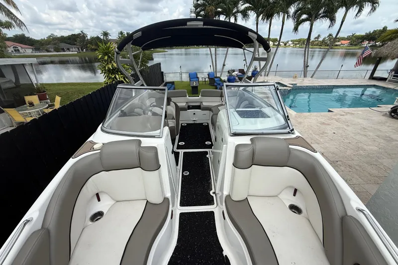 Slide: The Image of 2012 Yamaha Boats 242 Limited S docked by a poolside with scenic lake view. - 21