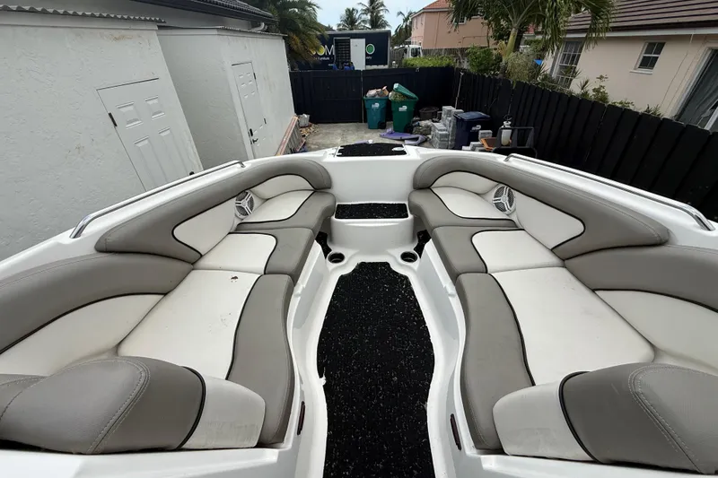 Slide: The Image of 2012 Yamaha Boats 242 Limited S interior with gray and white seating in a driveway. - 20
