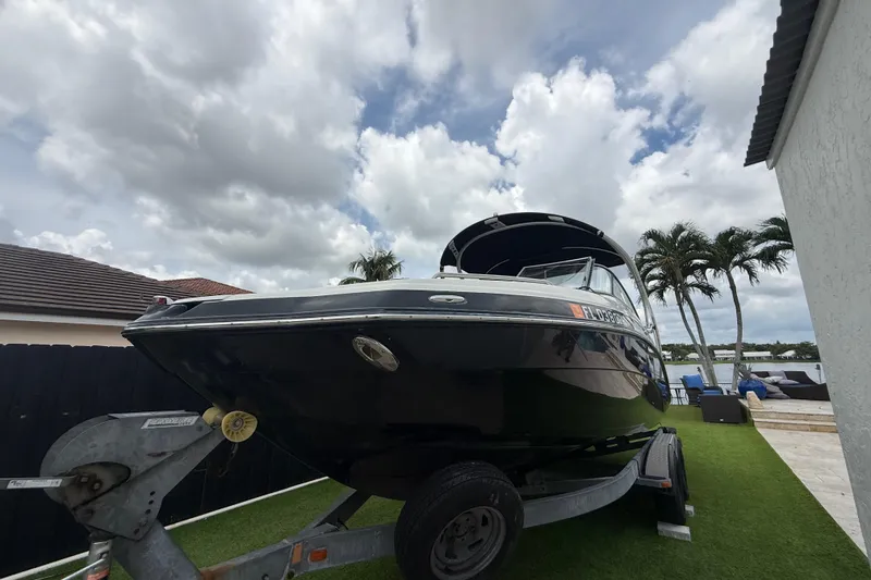 Slide: The Image of 2012 Yamaha Boats 242 Limited S on trailer, parked outdoors under cloudy sky. - 29
