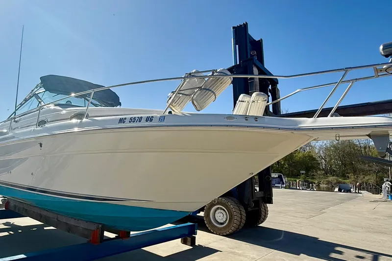 Slide: The Image of 1997 Sea Ray 270 Sundancer boat on a lift under clear blue sky. - 11