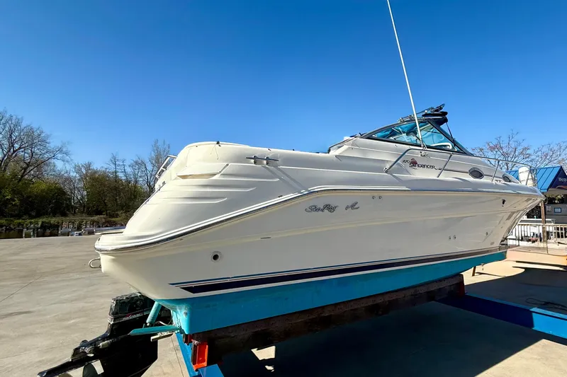 Slide: The Image of 1997 Sea Ray 270 Sundancer boat on display under clear blue sky. - 12