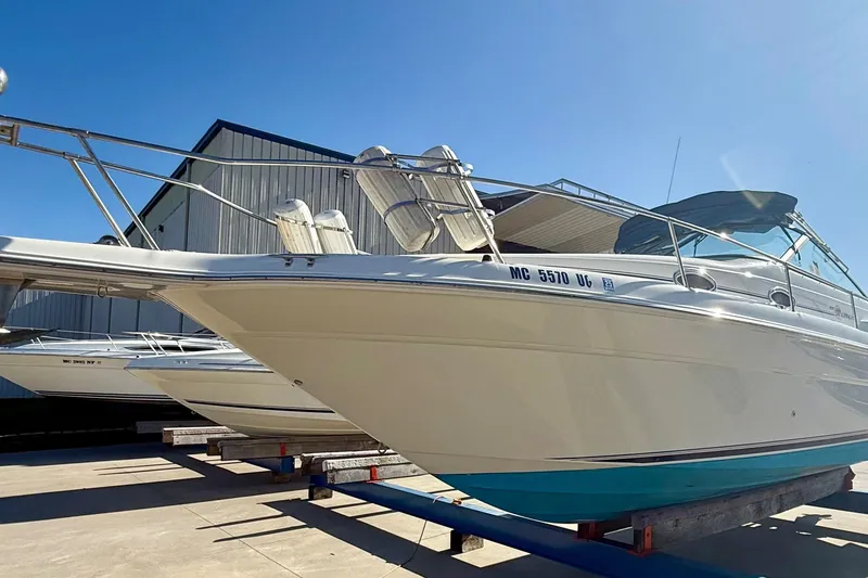 Slide: The Image of 1997 Sea Ray 270 Sundancer boat on dry dock under clear blue sky. - 13