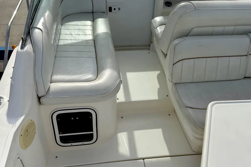 Slide: The Image of 1997 Sea Ray 270 Sundancer boat interior with white cushioned seating. - 16