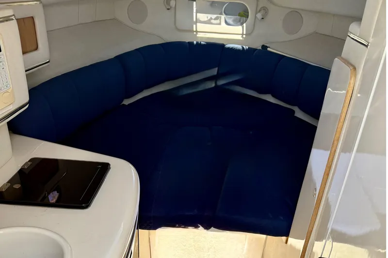 Slide: The Image of Interior cabin of 1997 Sea Ray 270 Sundancer with blue seating and kitchenette. - 17