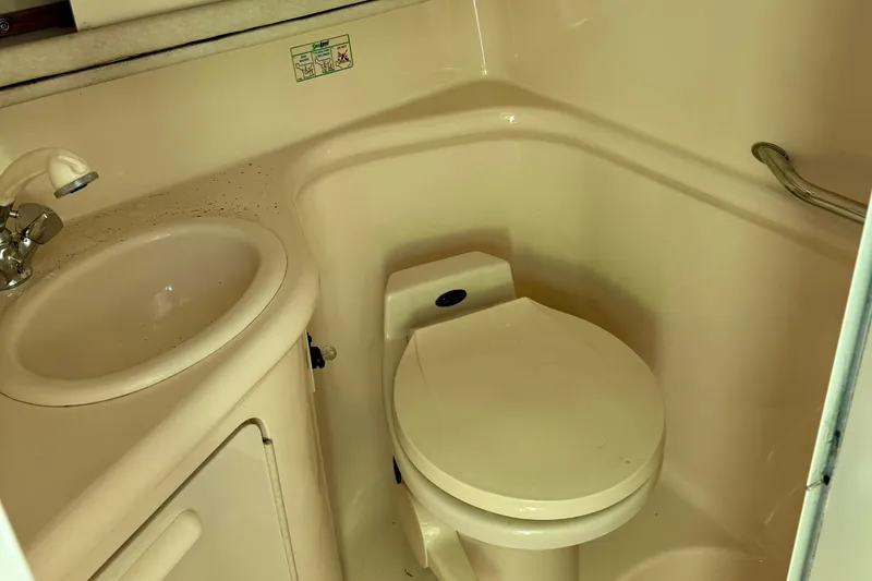 Slide: The Image of 1997 Sea Ray 270 Sundancer bathroom with sink and toilet, compact marine design. - 20