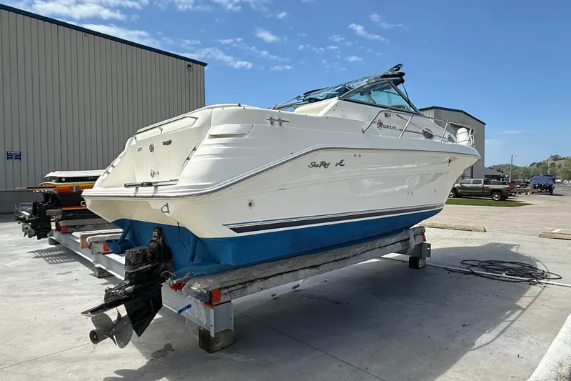 Slide: The Image of 1997 Sea Ray 270 Sundancer boat on trailer, parked outdoors under clear blue sky. - 3