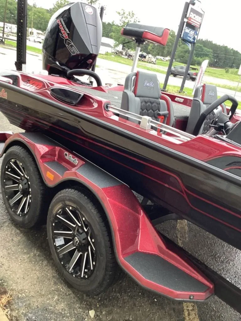 Slide: The Image of 2026 Bass Cat Eyra SP boat with trailer, red and black, parked. - 16